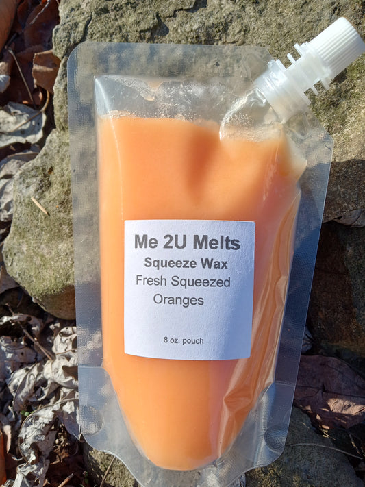 Orange wax product in a clear packaging with a label on a rocky surface